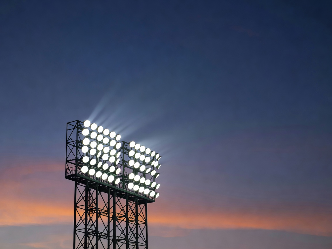 An elevated stadium floodlight array visible against the evening sky